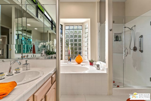 bathroom with shower with separate bathtub, vanity, and tile patterned floors