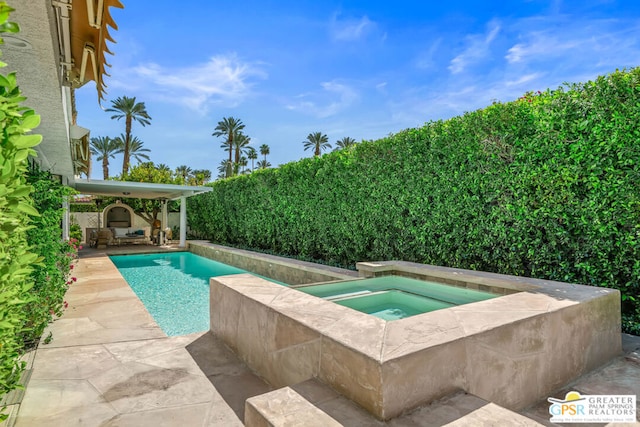 view of pool with an in ground hot tub and a patio