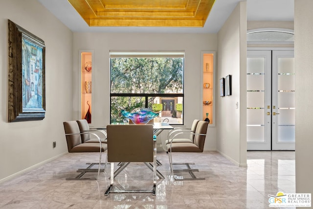 dining area featuring french doors and a raised ceiling