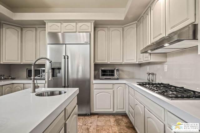 kitchen with stainless steel appliances, white cabinetry, a raised ceiling, and sink