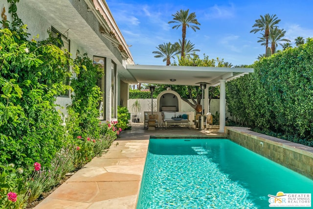 view of swimming pool featuring exterior fireplace and a patio area