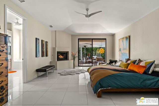 tiled bedroom featuring ensuite bathroom, access to outside, ceiling fan, and a tray ceiling