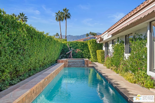 view of pool with a mountain view and an in ground hot tub