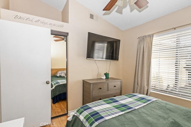 bedroom with ceiling fan, vaulted ceiling, and wood-type flooring