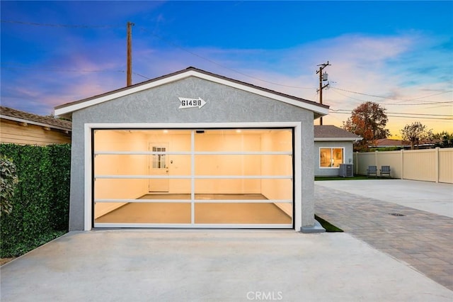 outdoor structure at dusk with central AC unit and a garage