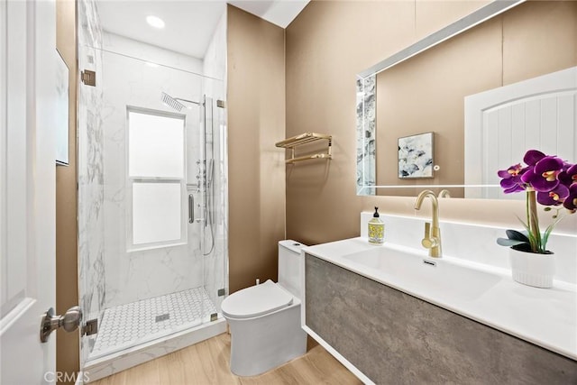 bathroom featuring toilet, hardwood / wood-style floors, an enclosed shower, and vanity