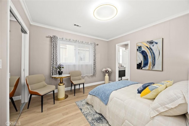 bedroom featuring a closet, light hardwood / wood-style flooring, and crown molding