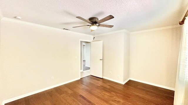 spare room with ceiling fan, dark wood-type flooring, ornamental molding, and a textured ceiling