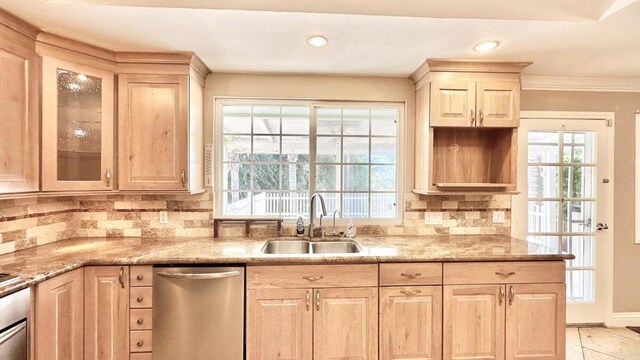 kitchen featuring tasteful backsplash, light stone countertops, dishwasher, and sink