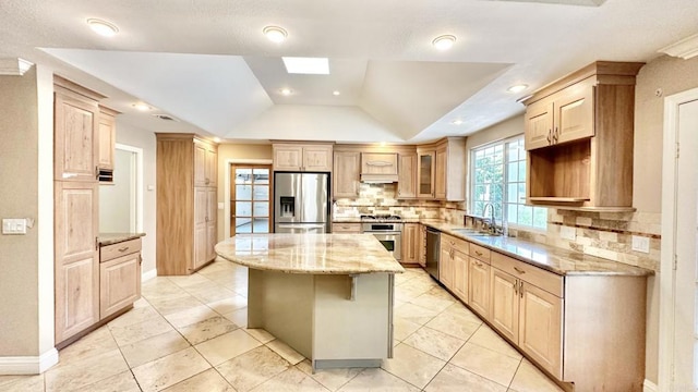 kitchen with tasteful backsplash, appliances with stainless steel finishes, a tray ceiling, and a kitchen island