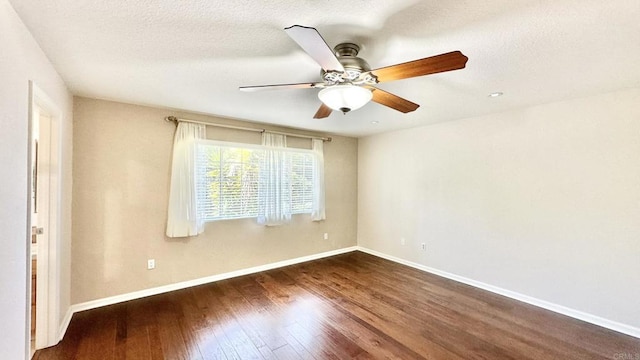 empty room with ceiling fan, dark wood-type flooring, and a textured ceiling