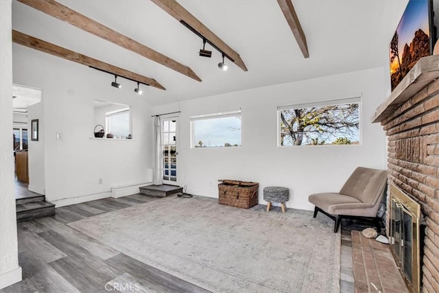 living area featuring hardwood / wood-style floors, beam ceiling, and a fireplace