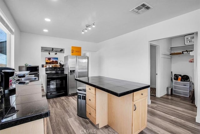 kitchen with tile countertops, appliances with stainless steel finishes, dark hardwood / wood-style flooring, light brown cabinetry, and sink