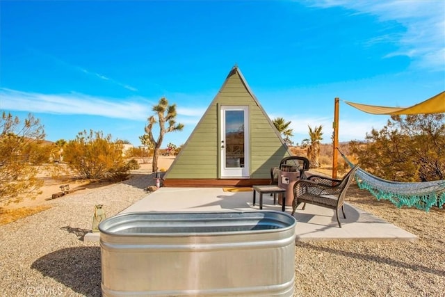 59427 La Crescenta Dr, Yucca Valley, CA 92284 - view of patio / terrace with a jacuzzi and an outdoor structure
