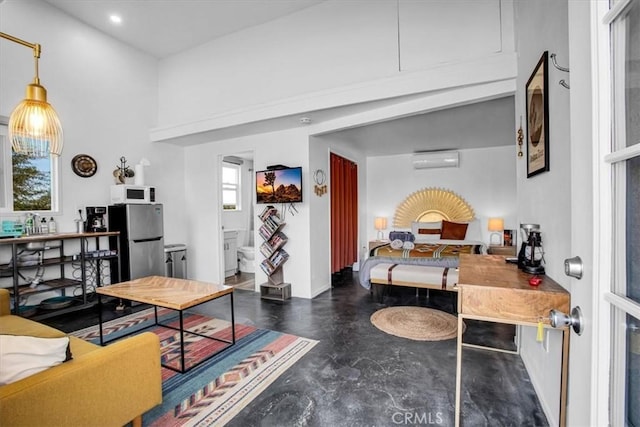 59427 La Crescenta Dr, Yucca Valley, CA 92284 - interior space featuring freestanding refrigerator, a wall mounted AC, recessed lighting, a towering ceiling, and finished concrete flooring