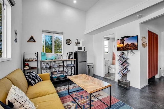 living room with a healthy amount of sunlight, a towering ceiling, and sink