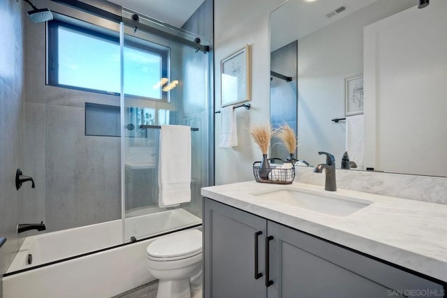 full bathroom with toilet, bath / shower combo with glass door, and vanity