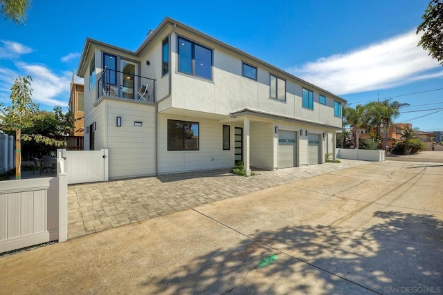 back of house featuring a balcony and a garage