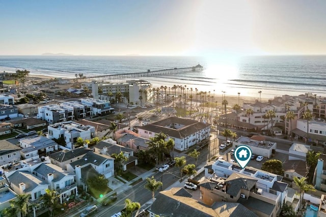 birds eye view of property with a water view and a beach view