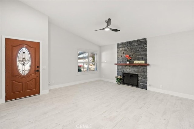 unfurnished living room featuring vaulted ceiling, ceiling fan, a fireplace, and light hardwood / wood-style flooring