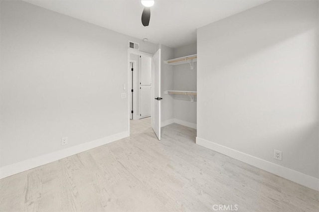 unfurnished bedroom with ceiling fan, a closet, and light wood-type flooring