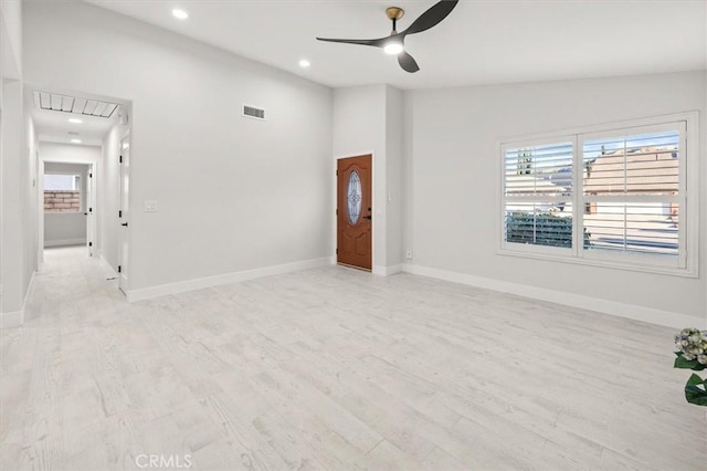 spare room with ceiling fan, light hardwood / wood-style floors, lofted ceiling, and a healthy amount of sunlight