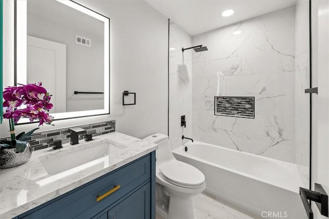 full bathroom featuring toilet, vanity, tiled shower / bath, and tasteful backsplash