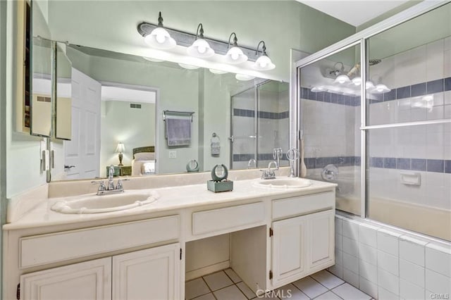 bathroom with bath / shower combo with glass door, vanity, and tile patterned floors