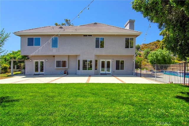 back of property featuring a fenced in pool, french doors, a patio area, and a yard