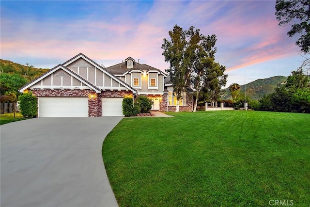 view of front of property with a garage, a mountain view, and a yard