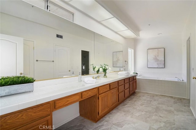 bathroom featuring vanity and a relaxing tiled tub