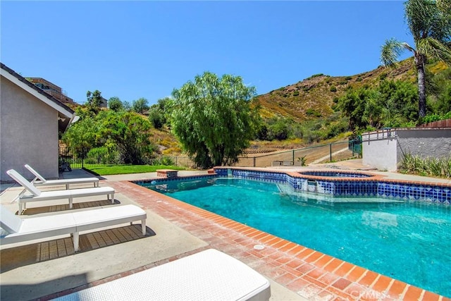 view of swimming pool featuring an in ground hot tub, a patio area, and a mountain view