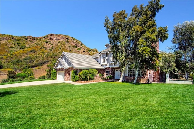 view of front of home featuring a front lawn, a mountain view, and a garage