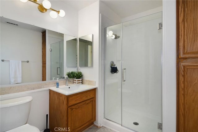 bathroom with vanity, toilet, and a shower with door