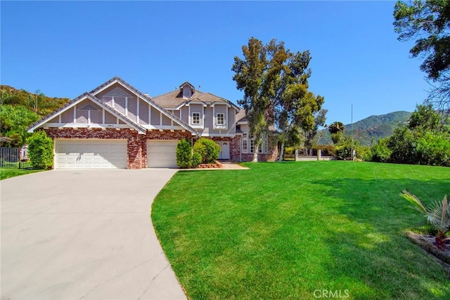 view of front of property with a front yard, a garage, and a mountain view