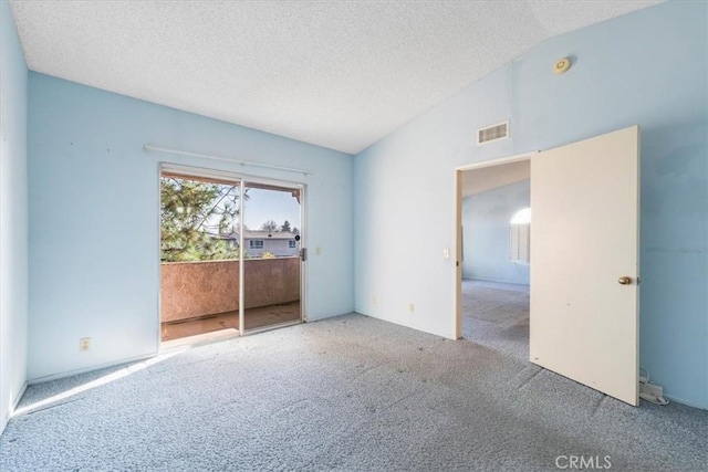 unfurnished room with vaulted ceiling, a textured ceiling, and carpet floors