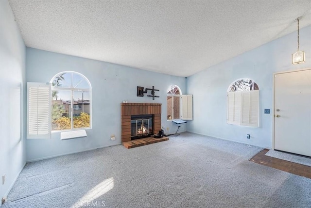 unfurnished living room featuring carpet floors, a fireplace, and a textured ceiling