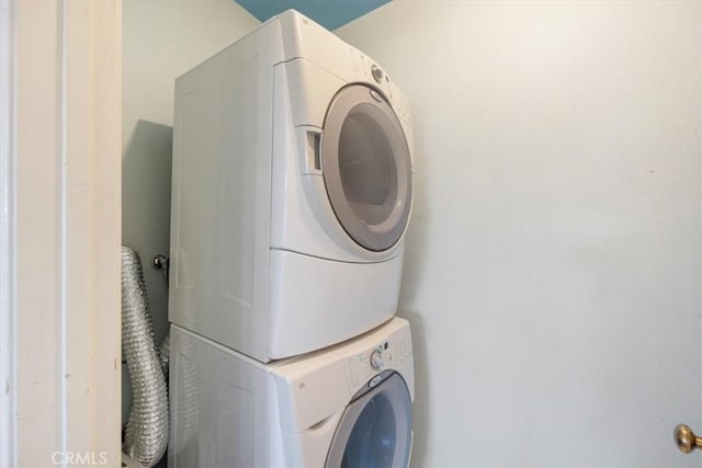 clothes washing area with stacked washer and clothes dryer