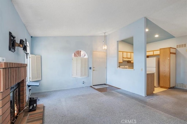 unfurnished living room with vaulted ceiling and carpet floors