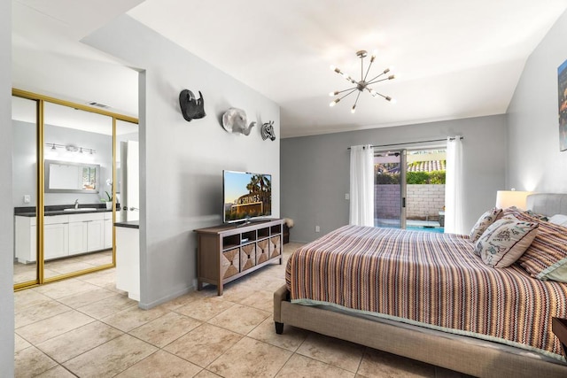 bedroom with light tile patterned floors, sink, an inviting chandelier, and connected bathroom