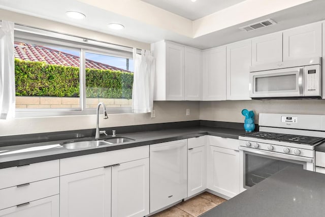 kitchen with sink, white appliances, and white cabinetry