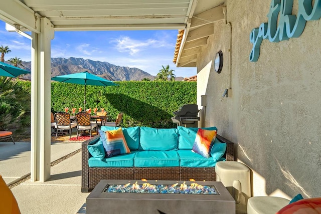 view of patio with grilling area, an outdoor living space, and a mountain view