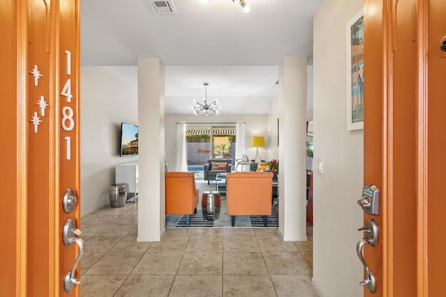 tiled entryway with an inviting chandelier