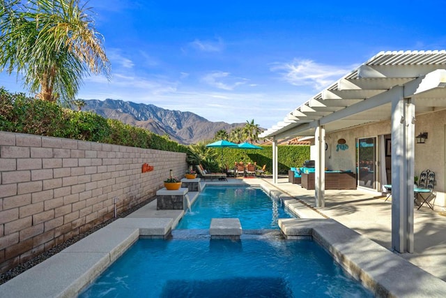 view of swimming pool with an outdoor hangout area, pool water feature, a mountain view, and a patio