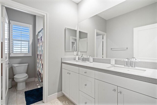 bathroom with toilet, tile patterned flooring, and vanity