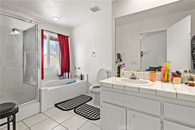 full bathroom featuring toilet, vanity, tile patterned floors, and shower with separate bathtub