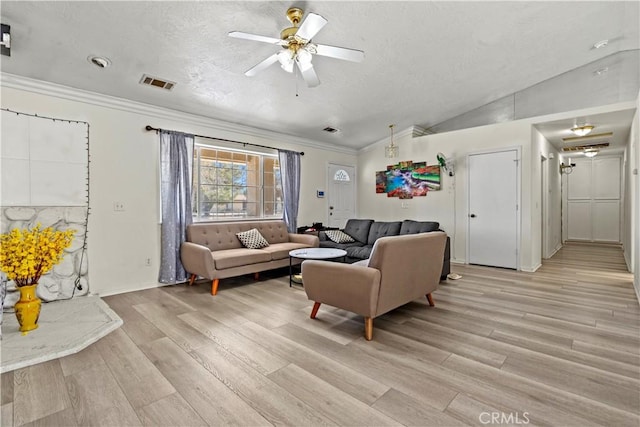 living room with ceiling fan, vaulted ceiling, light hardwood / wood-style flooring, a textured ceiling, and ornamental molding