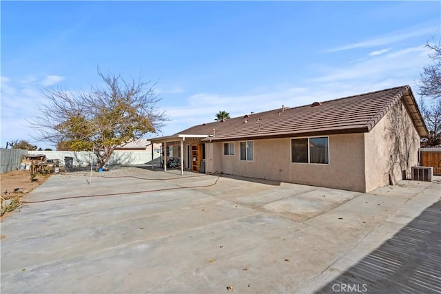 rear view of house featuring central AC unit and a patio