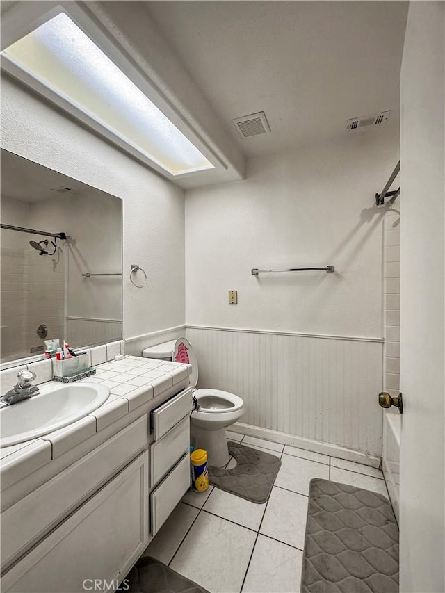 full bathroom with toilet, vanity, tiled shower / bath, and tile patterned flooring