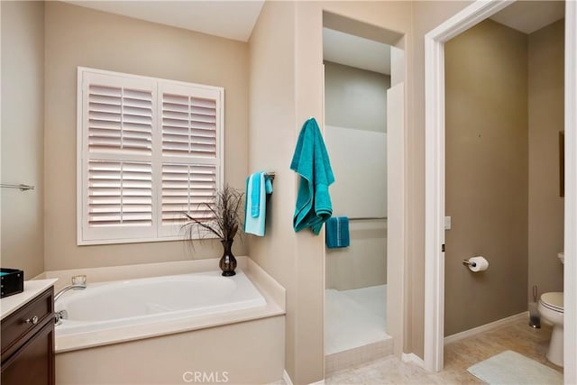 bathroom featuring a tub to relax in, vanity, and toilet